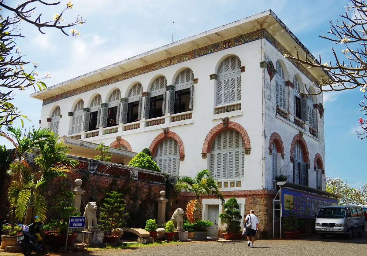 White colonial villa Bach Dinh with arched windows and red trim