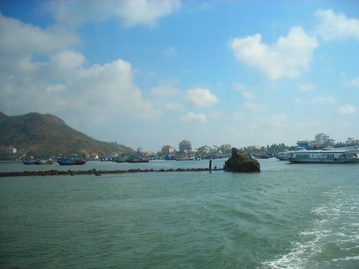Front Beach bay with moored boats, rocky hill and bright clouds