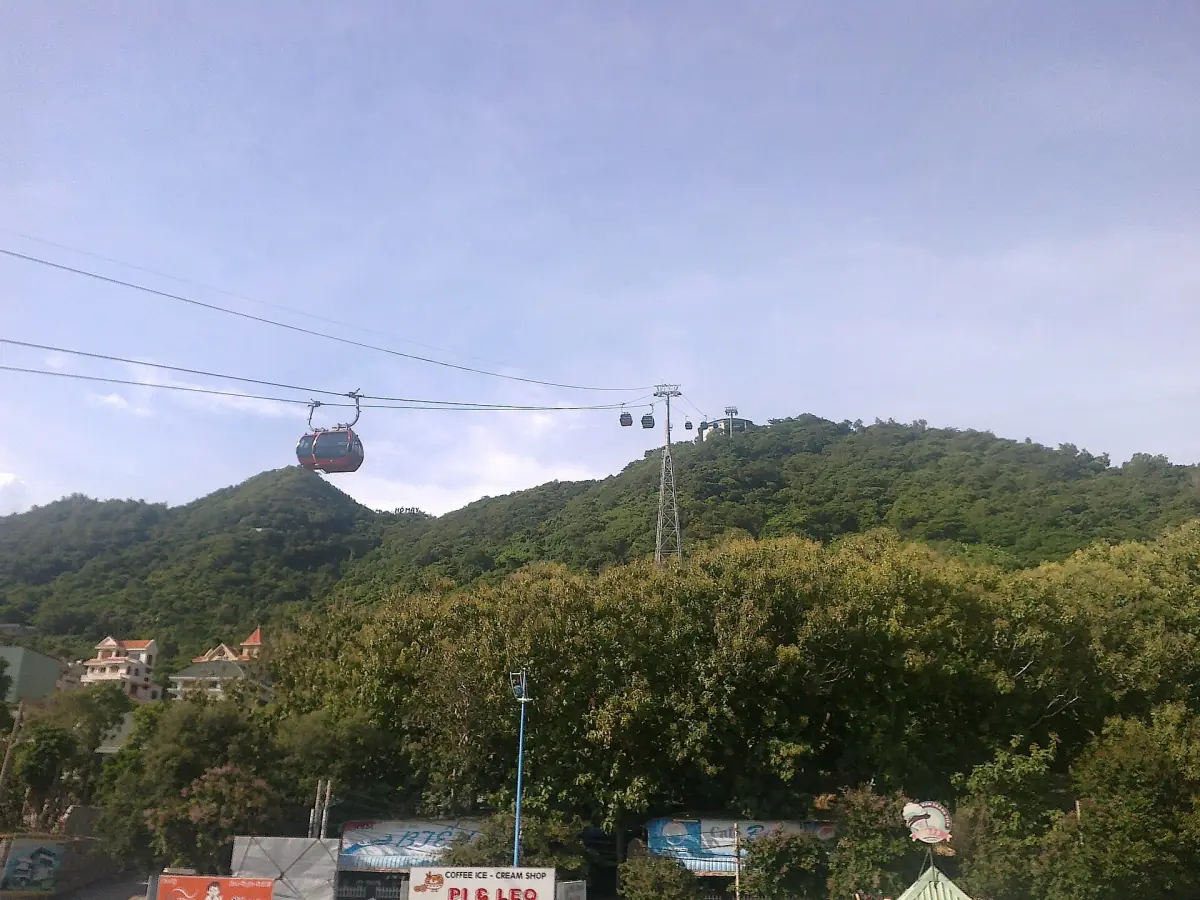 Cable car gondolas above green forested hill of Nui Lon near Cloud Lake