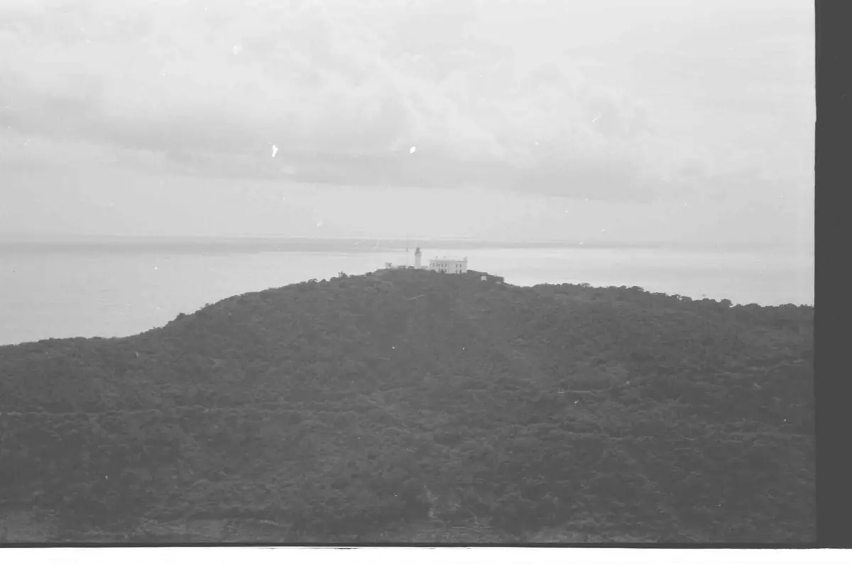 Black and white archive view of the forested hill with the lighthouse